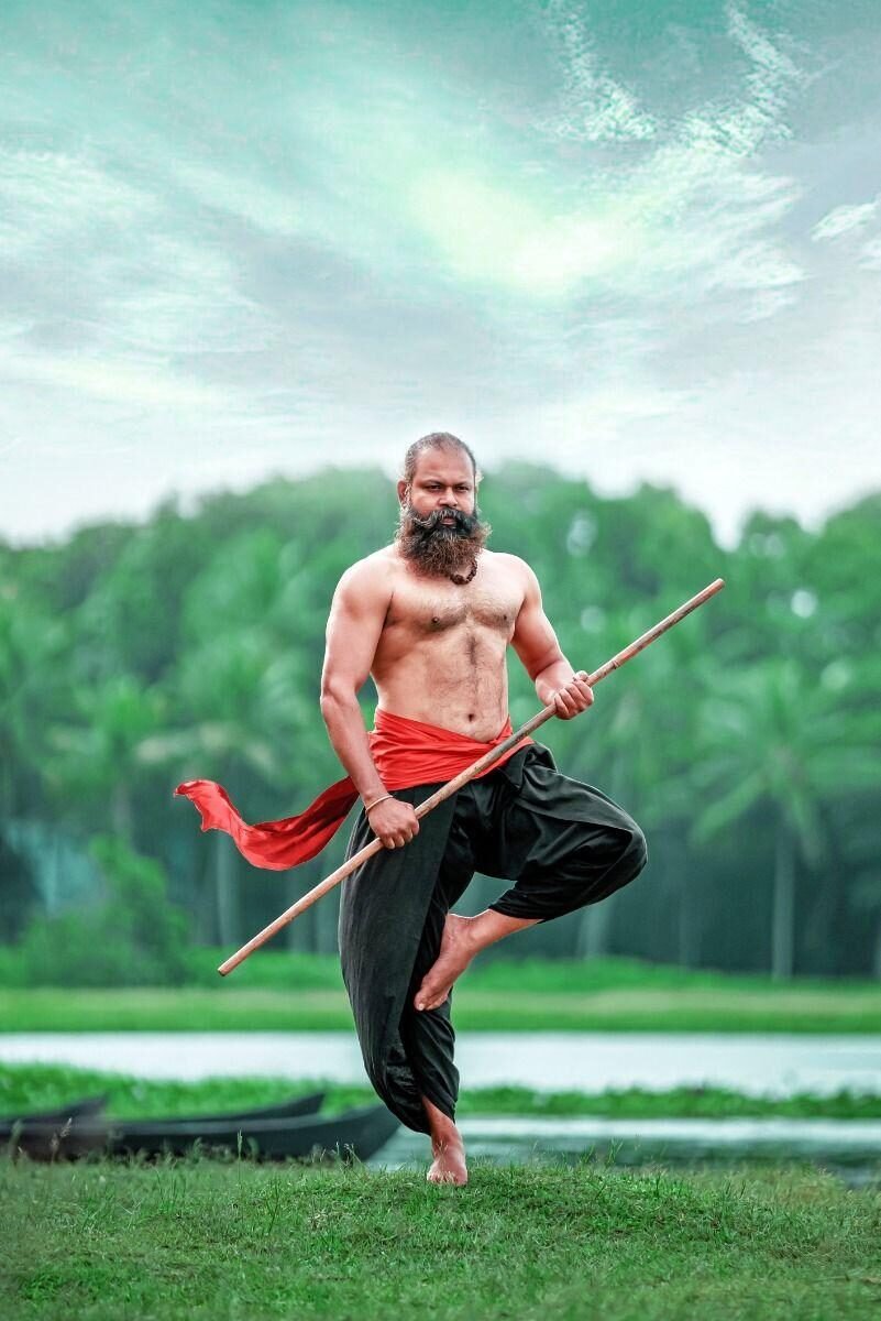 Lathi warrior practicing traditional Kalaripayattu stick technique by the water